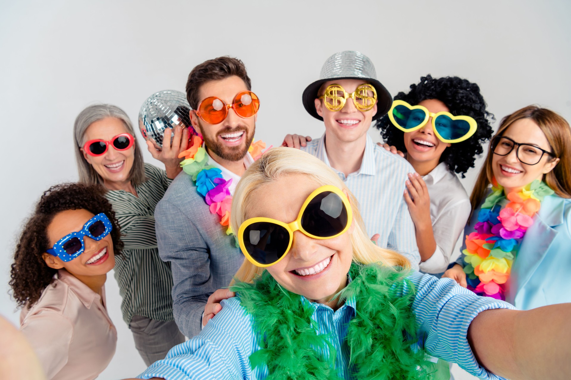 Diverse colleagues in festive accessories smiling together for a celebratory group photo
